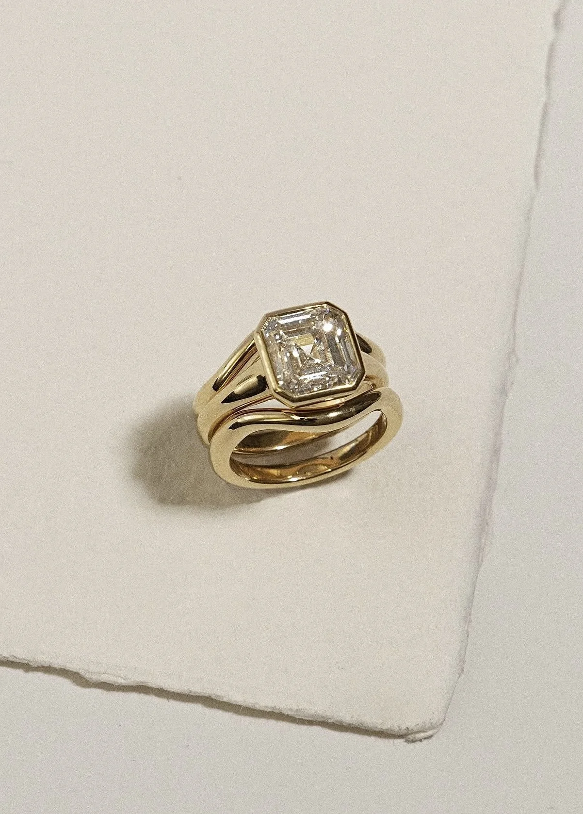 Asscher-cut engagement ring stacked with a gold band